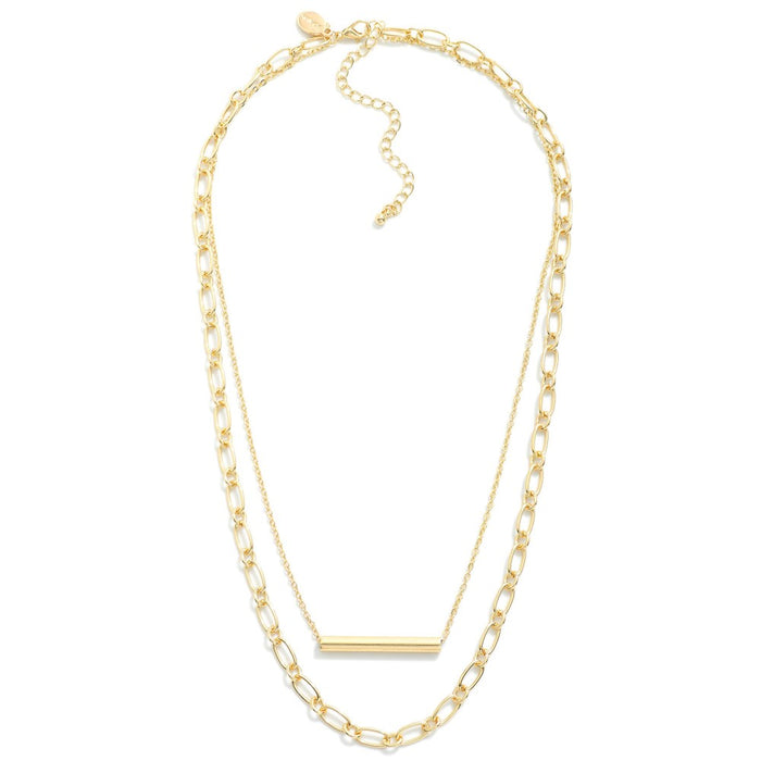 Gold metal layered chain link necklace with a metal tube bead focal, approximately 18" in length with a 3" extender, perfect for adding a sophisticated touch to any outfit.