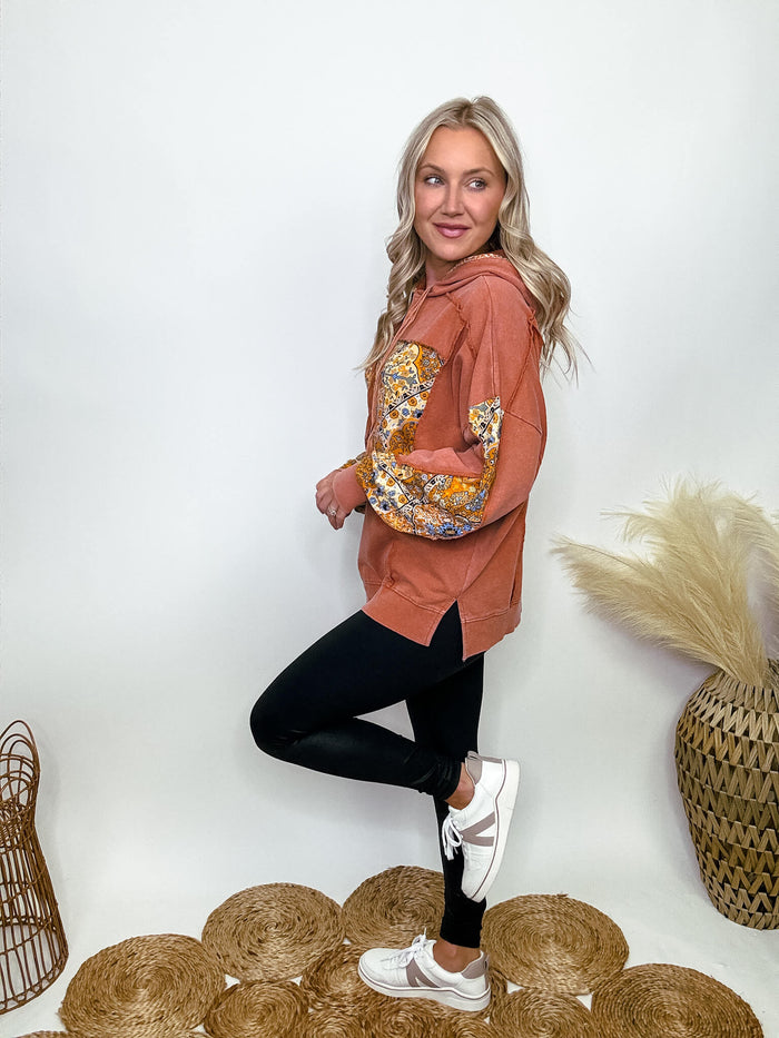 Easel Cinnamon washed hoodie pullover with paisley floral print patches, long sleeves, mineral-washed fabric, dropped shoulders, side slits, ribbed band cuffs and hem, raw cut seams, and mixed pattern detailing.