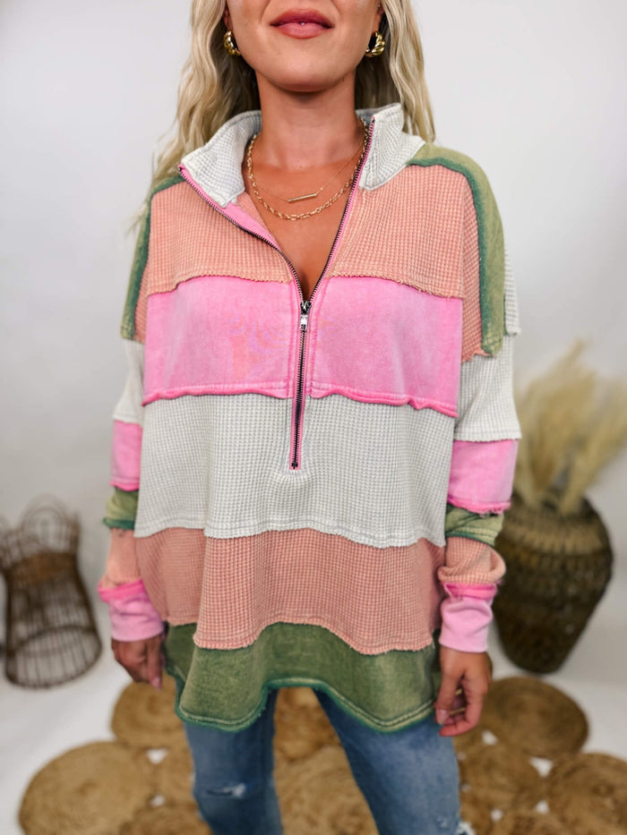 Oli & Hali Mineral washed long sleeve pullover with half zip collar, colorblock stripes in pink, cream, peach, and green, and side pockets, featuring raw edge and exposed seam details.