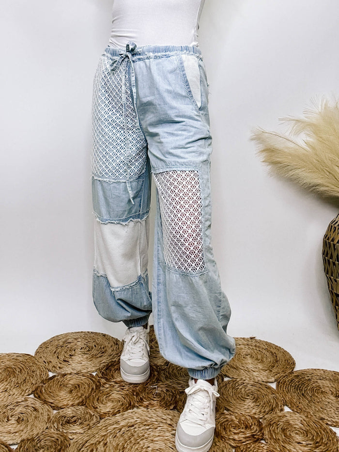 POL Clothing Chambray denim jogger pants with thermal and crochet patches, side pockets, and adjustable waist drawstring.