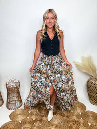 Promesa Vintage Floral Boho Maxi Skirt with Front Slit and Smocked Stretchy Waistband, Styled with Black Vest and White Booties at Bmaes Boutique