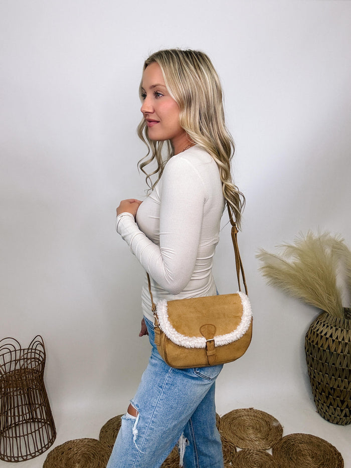 Tan camel suede cross body bag with cozy sherpa detail, featuring a magnetic buckle closure and adjustable strap, perfect for fall and winter style.