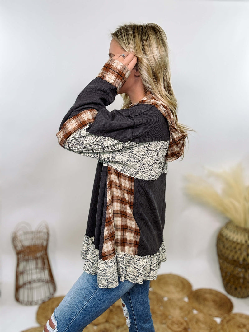 Charcoal thermal Henley by POL with plaid patchwork and lace details. Features Henley button neckline, plaid hoodie, and flowy oversized fit with ruffle hem. Perfect for cozy fall or winter outfits.