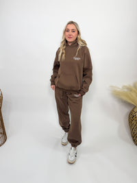 Chocolate brown fleece-lined luxury lounge Bmaes hoodie with embroidered Bmaes Boutique logo, drop shoulders, kangaroo pocket, and ribbed details. Perfect for cozy lounging or pairing with the matching joggers for a stylish, warm set from Bmaes Boutique.