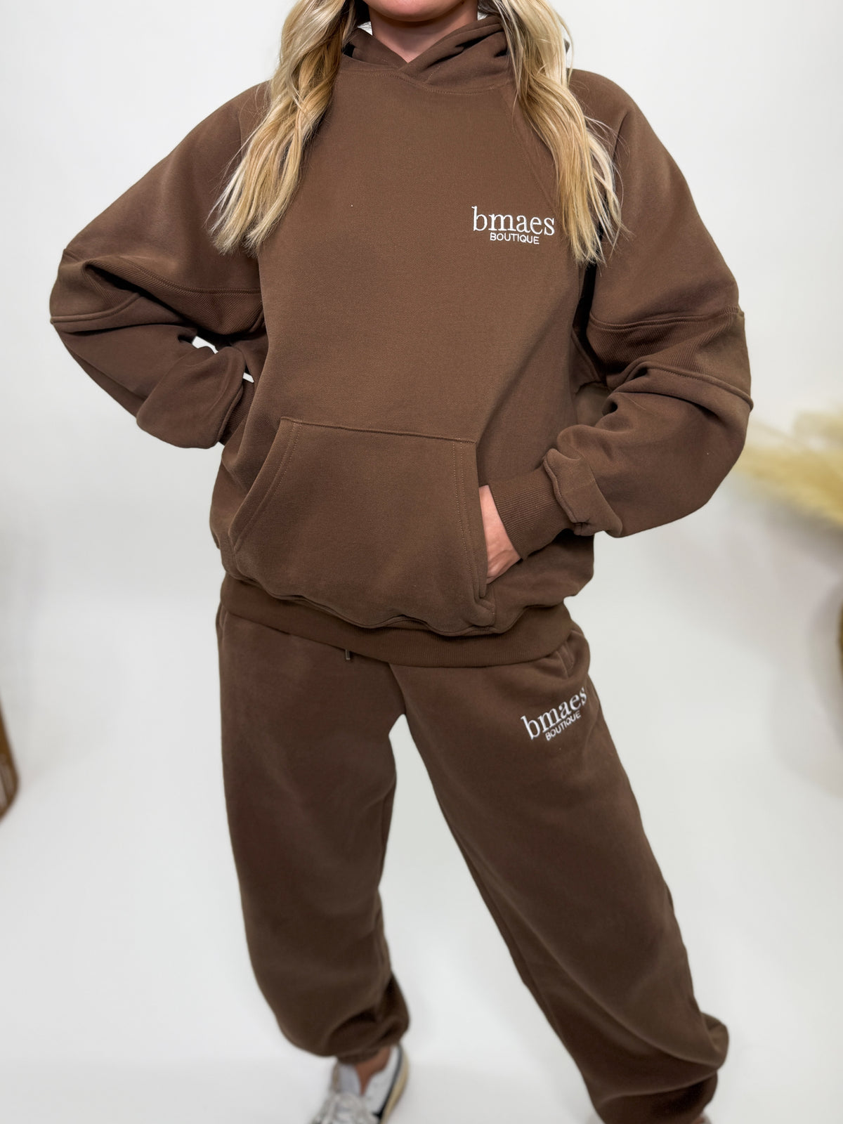 Chocolate brown fleece-lined luxury lounge Bmaes hoodie with embroidered Bmaes Boutique logo, drop shoulders, kangaroo pocket, and ribbed details. Perfect for cozy lounging or pairing with the matching joggers for a stylish, warm set from Bmaes Boutique.