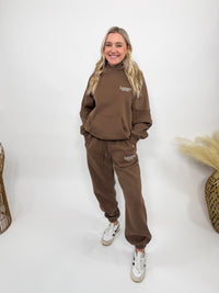 Chocolate brown fleece-lined luxury lounge Bmaes hoodie with embroidered Bmaes Boutique logo, drop shoulders, kangaroo pocket, and ribbed details. Perfect for cozy lounging or pairing with the matching joggers for a stylish, warm set from Bmaes Boutique.