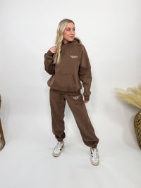 Chocolate brown fleece-lined luxury lounge Bmaes hoodie with embroidered Bmaes Boutique logo, drop shoulders, kangaroo pocket, and ribbed details. Perfect for cozy lounging or pairing with the matching joggers for a stylish, warm set from Bmaes Boutique.