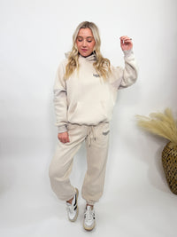 Cream fleece-lined luxury lounge Bmaes hoodie with embroidered Bmaes Boutique logo, drop shoulders, kangaroo pocket, and ribbed details. Perfect for cozy lounging or pairing with the matching joggers for a stylish, warm set from Bmaes Boutique.