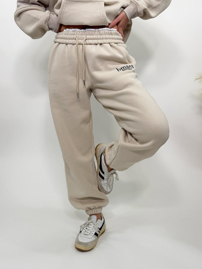 Cream fleece-lined luxury lounge Bmaes joggers with elastic drawstring waistband, deep pockets, and elastic ankle cuffs. Perfect for lounging or pairing with the matching hoodie for a chic, cozy set from Bmaes Boutique.