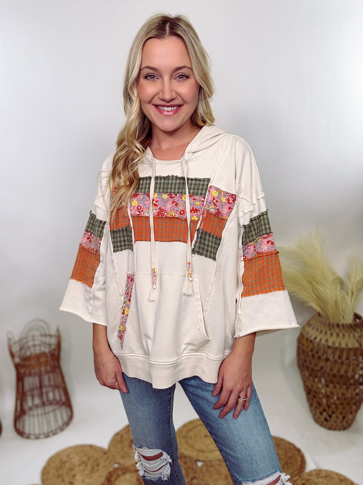 Easel Patchwork Hoodie with mixed plaid and floral patterns, 3/4 wide sleeves, raw hem, side slits, and a relaxed loose fit, made with 85% cotton, 15% polyester, and 5% spandex.