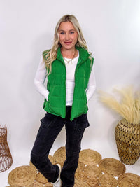 Vibrant green padded puffer vest with side slits and a zip-up front, perfect for layering and staying warm.