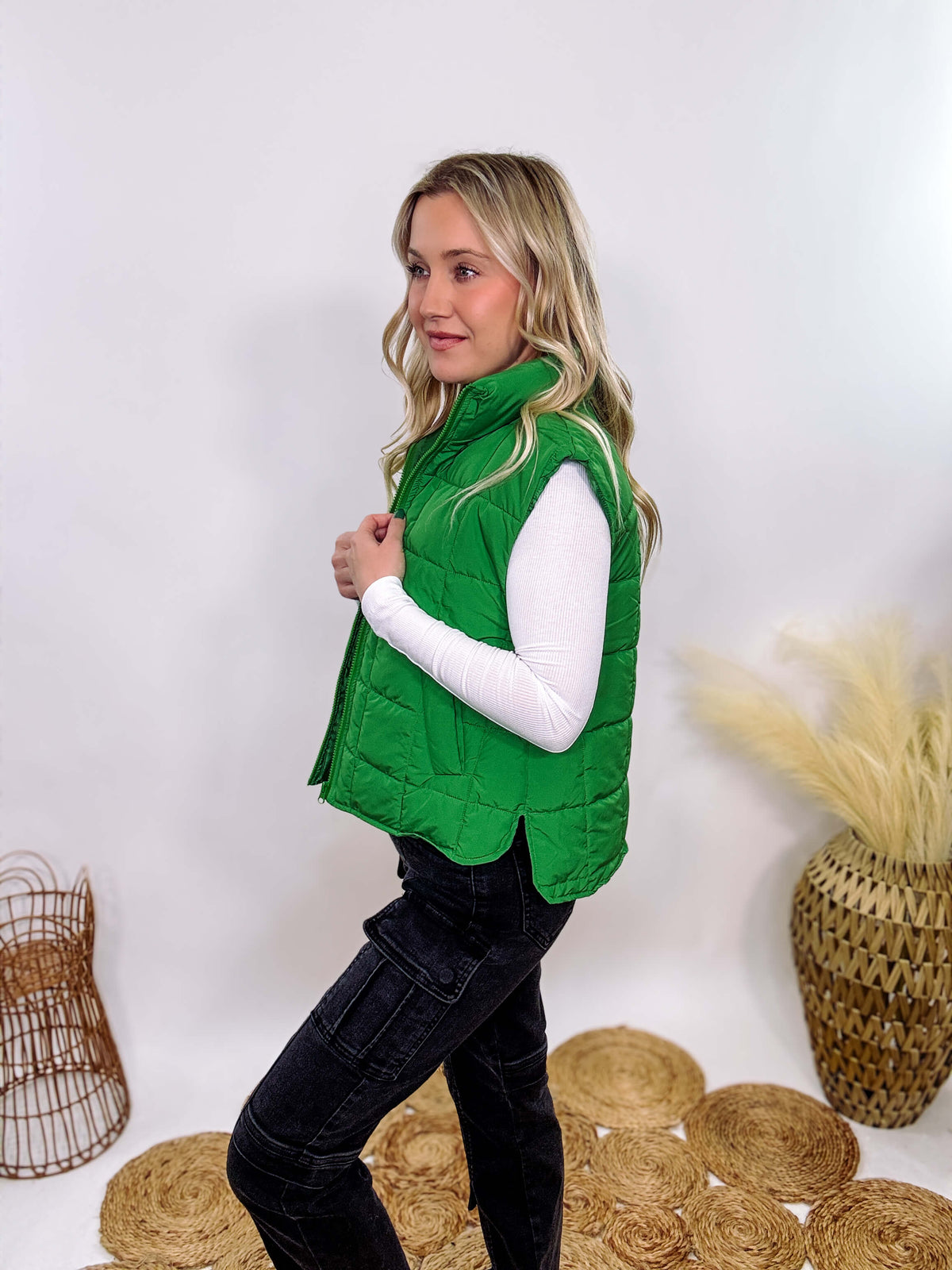 Vibrant green padded puffer vest with side slits and a zip-up front, perfect for layering and staying warm.