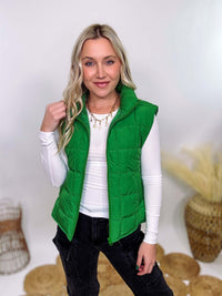 Vibrant green padded puffer vest with side slits and a zip-up front, perfect for layering and staying warm.