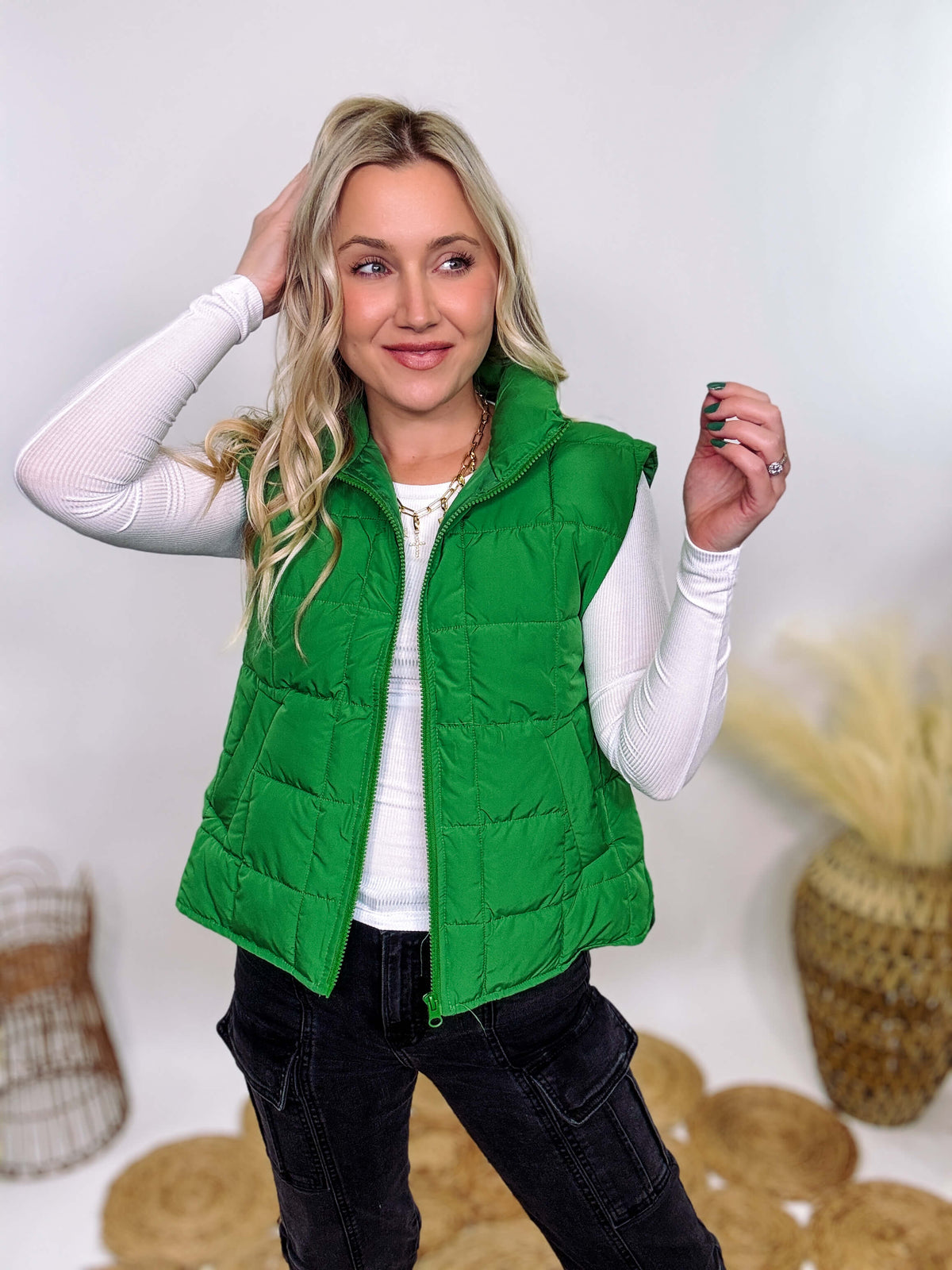 Vibrant green padded puffer vest with side slits and a zip-up front, perfect for layering and staying warm.