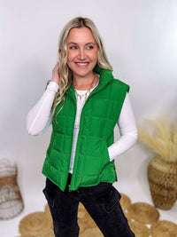 Vibrant green padded puffer vest with side slits and a zip-up front, perfect for layering and staying warm.