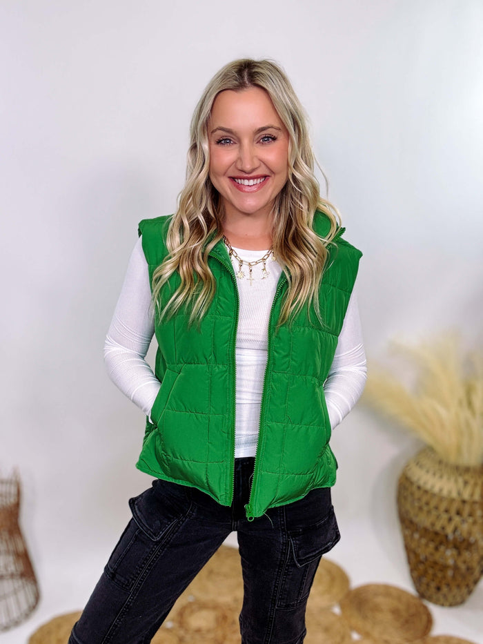 Vibrant green padded puffer vest with side slits and a zip-up front, perfect for layering and staying warm.