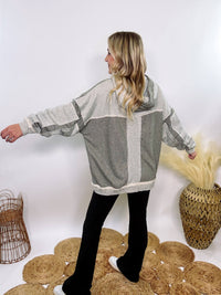 Grey olive patchwork oversized hoodie by Oli & Hali with contrast patchwork sleeves, drawstring hood, front kangaroo pocket, and exposed raw hems. Cozy and stylish design for everyday wear.