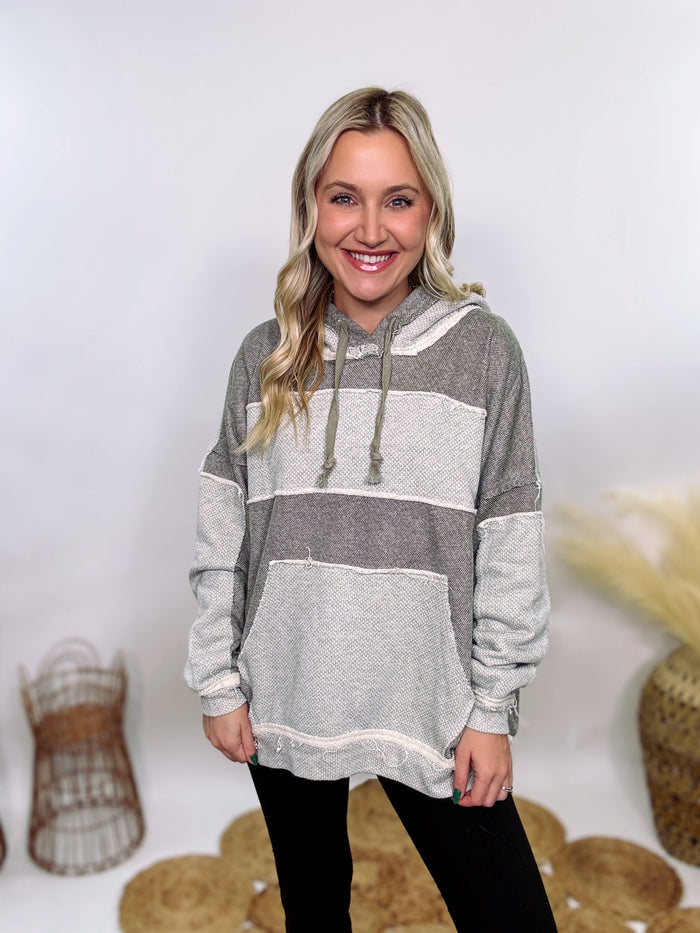 Grey olive patchwork oversized hoodie by Oli & Hali with contrast patchwork sleeves, drawstring hood, front kangaroo pocket, and exposed raw hems. Cozy and stylish design for everyday wear.