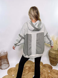 Grey olive patchwork oversized hoodie by Oli & Hali with contrast patchwork sleeves, drawstring hood, front kangaroo pocket, and exposed raw hems. Cozy and stylish design for everyday wear.