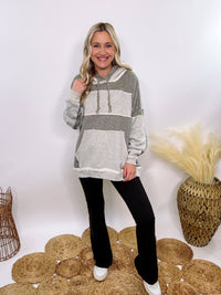 Grey olive patchwork oversized hoodie by Oli & Hali with contrast patchwork sleeves, drawstring hood, front kangaroo pocket, and exposed raw hems. Cozy and stylish design for everyday wear.