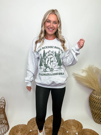 Heather grey fleece lined sweatshirt with a bear hiking graphic and the text 'The scenic route is always a good idea.' Perfect for fall outdoor activities. Model Brooke is 5'4" wearing size small.