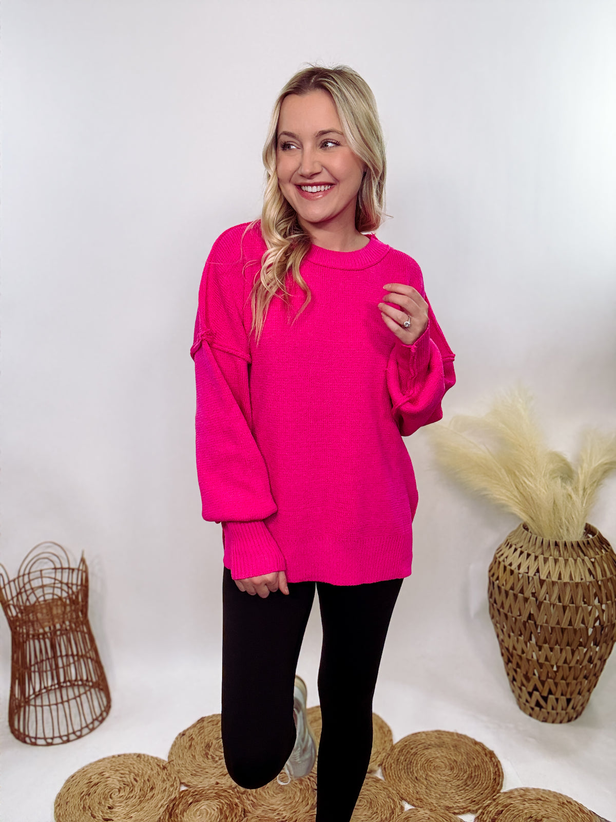 Hot pink oversized sweater with exposed seams, side slits, and a ribbed hem. Cozy, stylish, and perfect for brightening up your winter wardrobe.