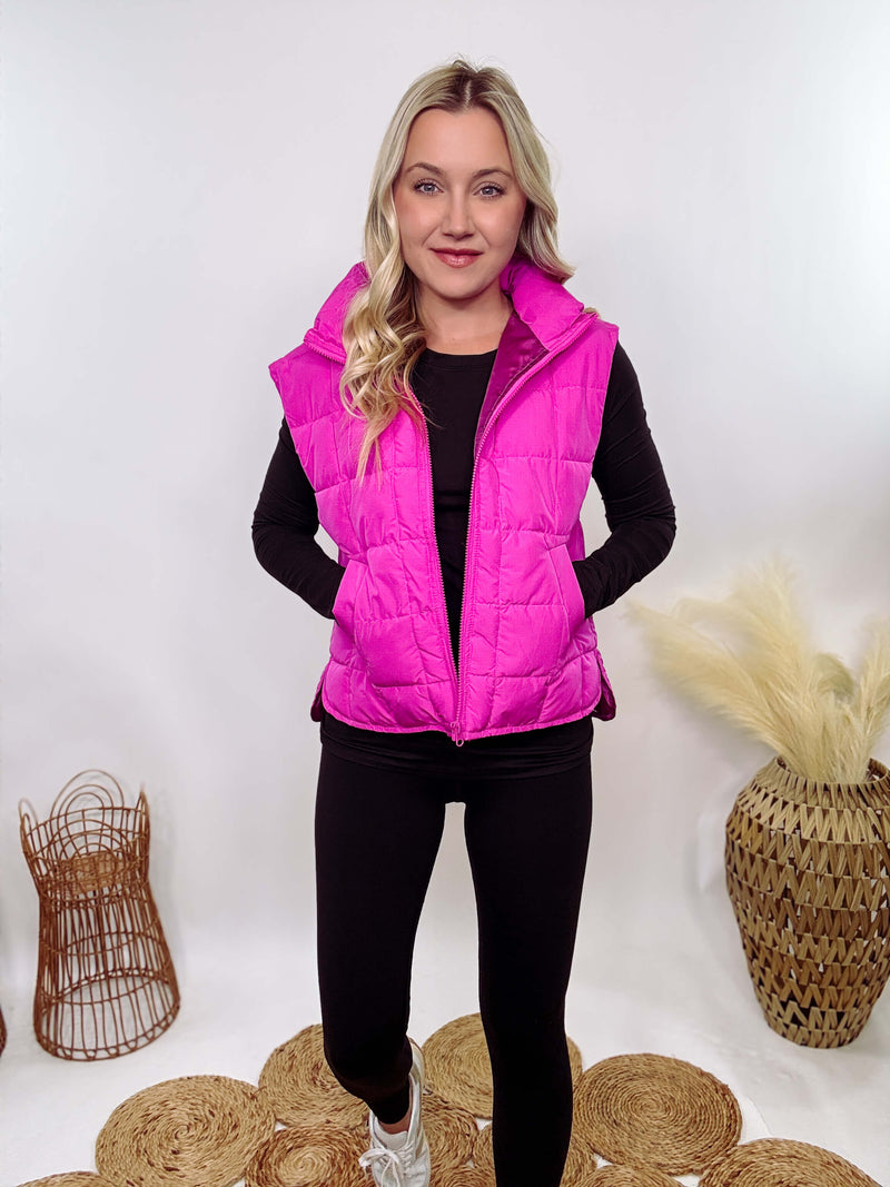 Hot Pink Zip-Up Puffer Vest with side slits and side pockets, perfect for layering in cooler spring weather.