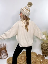 Creamy White Oversized Long Sleeve Sweater with a relaxed crew neckline, drop shoulders, ribbed knit cuffs and hem, and a soft, stretchy acrylic fabric.