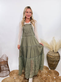 Boho olive green lace tiered overall maxi dress with adjustable straps, front chest pocket, and flowy silhouette