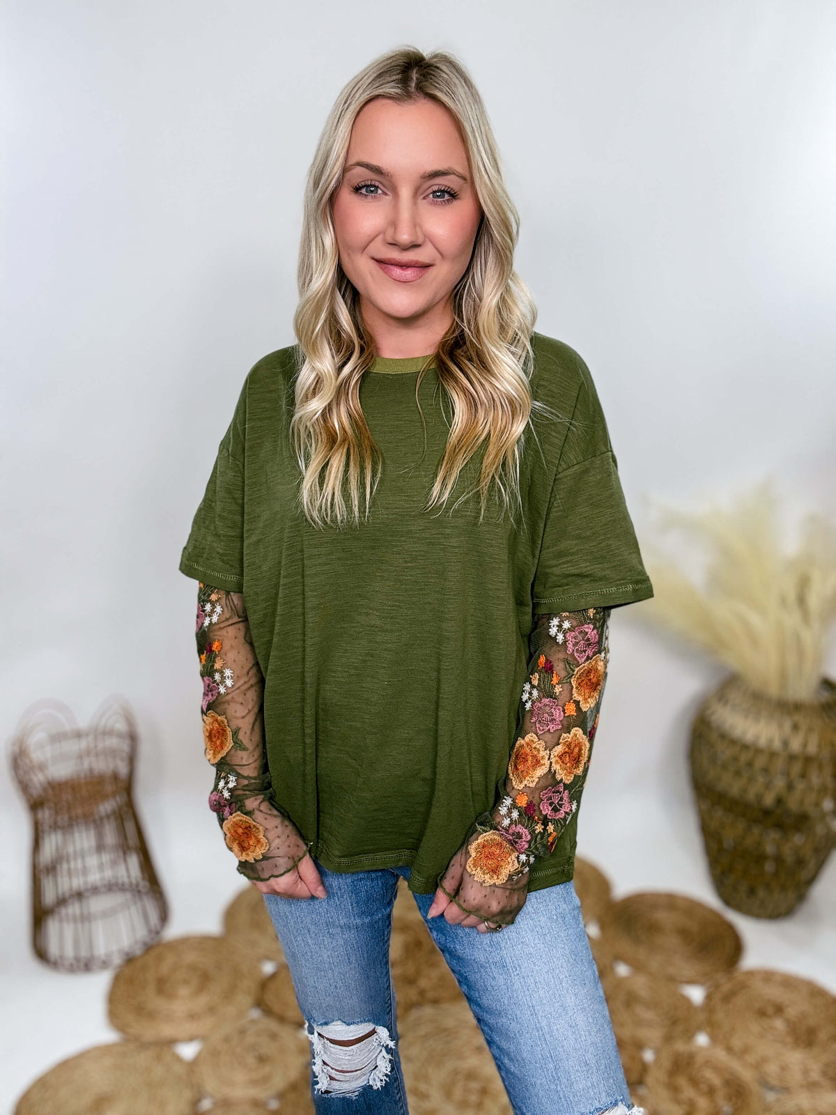 In Loom Oversized olive green tee with layered sheer embroidered floral lace mesh sleeves. Relaxed fit, earthy olive tone, and high-quality fabric blend. Perfect for casual fall outfits or dressing up with jeans or leather leggings. Feminine and edgy design ideal for crisp autumn days.