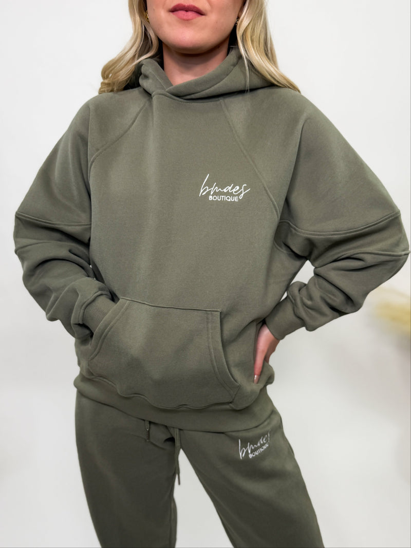 Olive green fleece-lined luxury lounge Bmaes hoodie with embroidered Bmaes Boutique logo, drop shoulders, kangaroo pocket, and ribbed details. Perfect for cozy lounging or pairing with the matching joggers for a stylish, warm set from Bmaes Boutique.