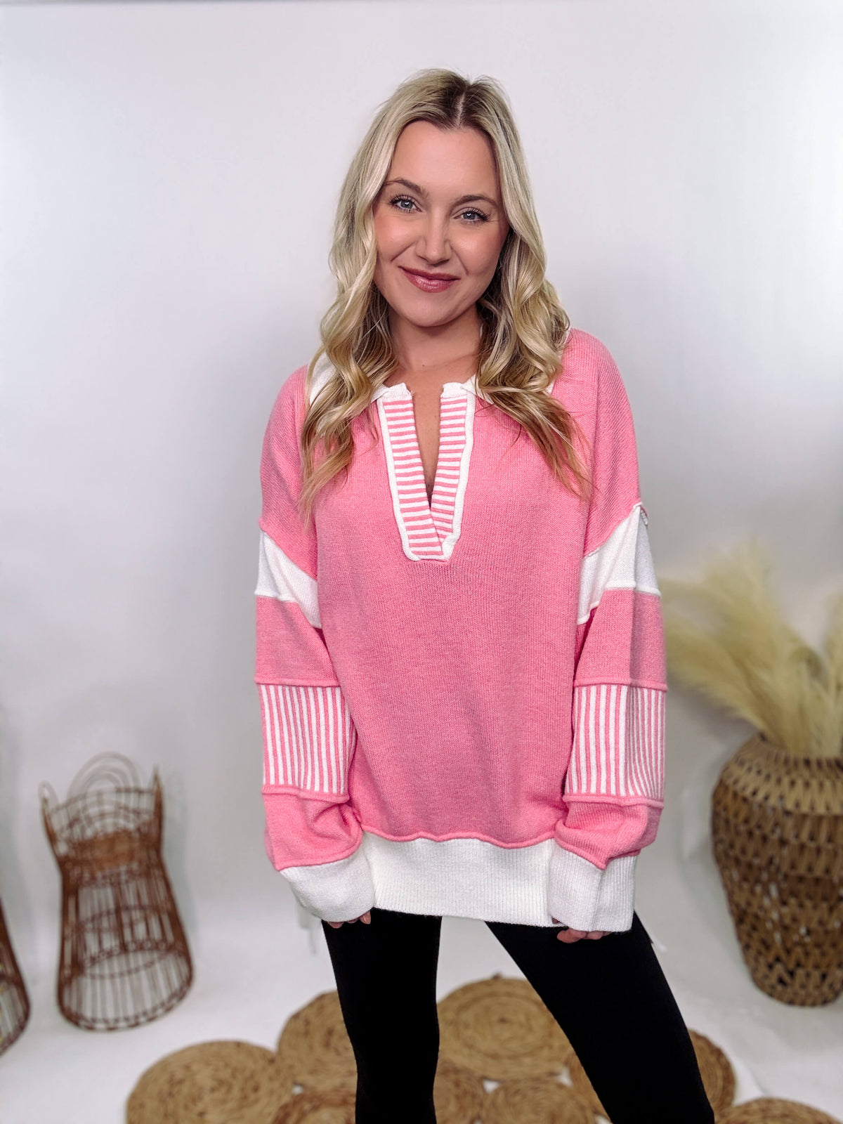 Pink Polo Preppy Style Sweater with ivory stripe patches on the sleeves and neckline, featuring a collared split neck design, long sleeves, high-low cut, and oversized fit, made of 100% polyester.