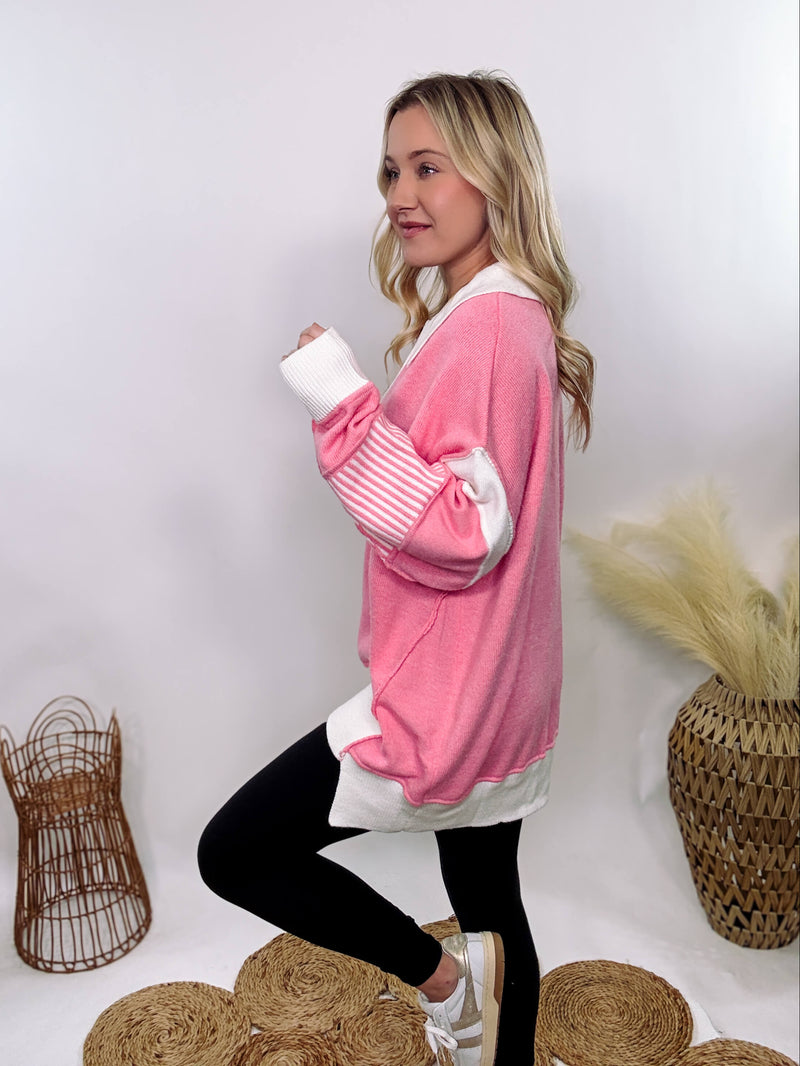 vPink Polo Preppy Style Sweater with ivory stripe patches on the sleeves and neckline, featuring a collared split neck design, long sleeves, high-low cut, and oversized fit, made of 100% polyester.