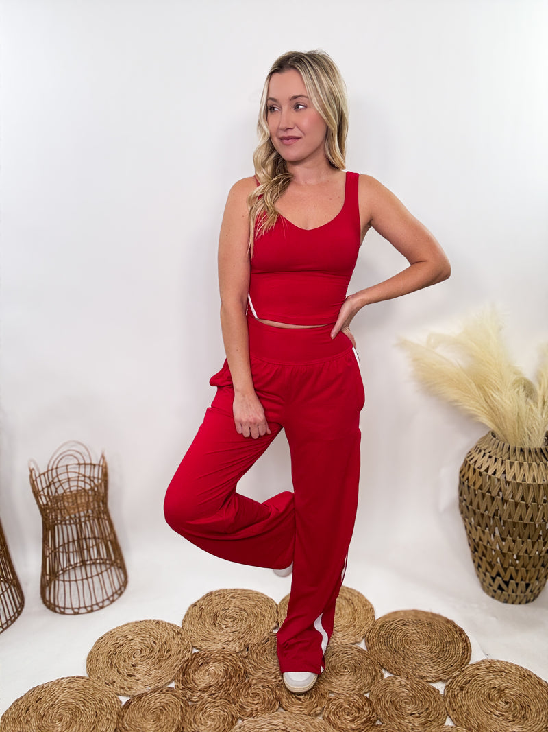 Red & White Sporty Matching Lounge Set featuring a V-neck crop tank with contrast white piping and high-waisted straight-leg pants. Designed with a relaxed fit, 4-way stretch fabric, and sporty chic details, perfect for lounging, workouts, and casual outings.