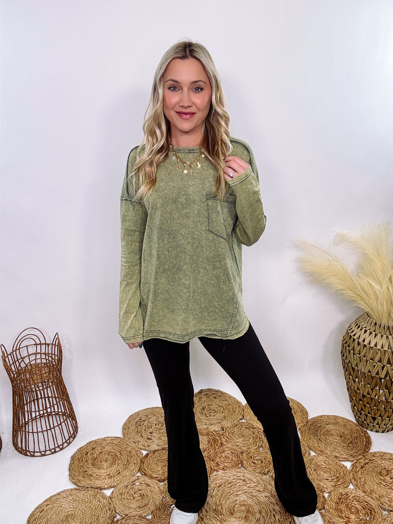 Sage Green Acid Washed Long Sleeve Top with Raw Edge Detail, Chest Pocket, and Relaxed Fit – Perfect for Casual Outfits with Leggings and Sneakers.