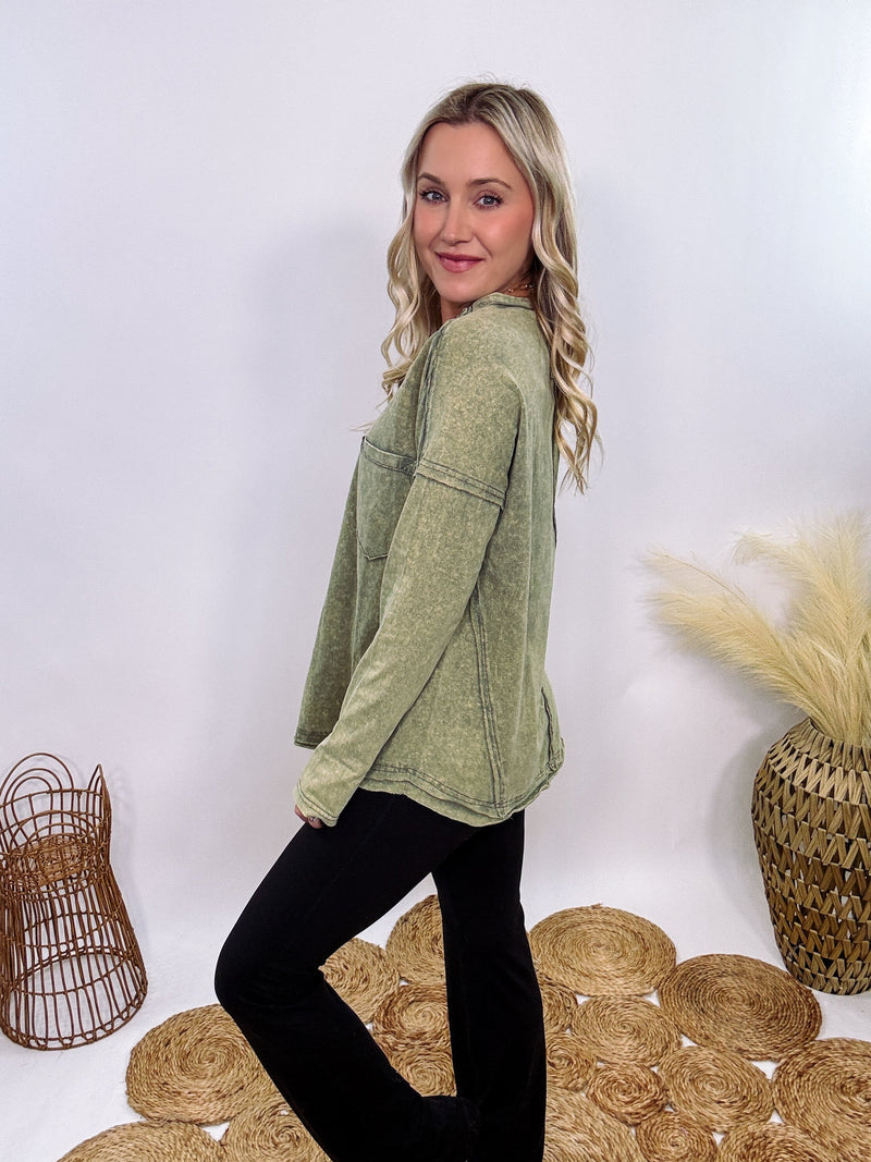 Sage Green Acid Washed Long Sleeve Top with Raw Edge Detail, Chest Pocket, and Relaxed Fit – Perfect for Casual Outfits with Leggings and Sneakers.