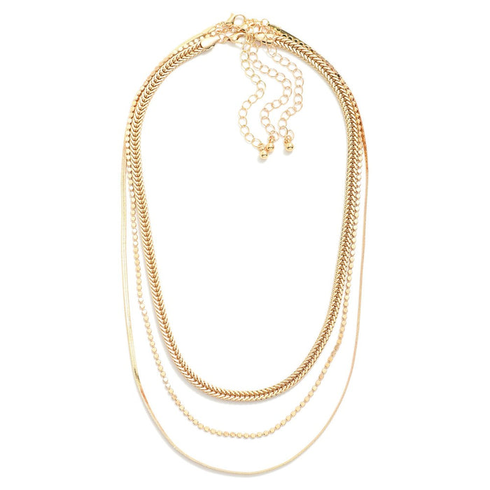 Set of three gold chain necklaces featuring herringbone chain and flat ball chain with extender.