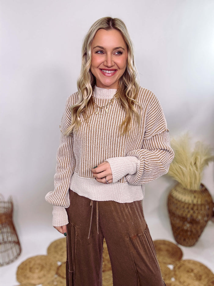 Very J Two-tone neutral ribbed sweater featuring a cream body with light brown ribbed detailing, round neck, and loose fit. Made from 100% polyester with a soft, non-scratchy feel. Styled with a neutral beanie and kick flare denim for a cozy winter look.