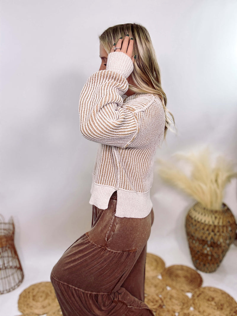 Very J Two-tone neutral ribbed sweater featuring a cream body with light brown ribbed detailing, round neck, and loose fit. Made from 100% polyester with a soft, non-scratchy feel. Styled with a neutral beanie and kick flare denim for a cozy winter look.