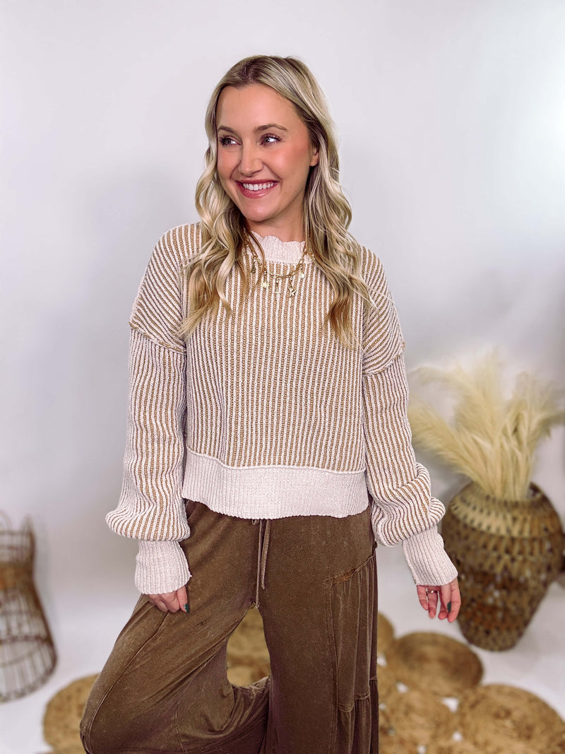 Very J Two-tone neutral ribbed sweater featuring a cream body with light brown ribbed detailing, round neck, and loose fit. Made from 100% polyester with a soft, non-scratchy feel. Styled with a neutral beanie and kick flare denim for a cozy winter look.