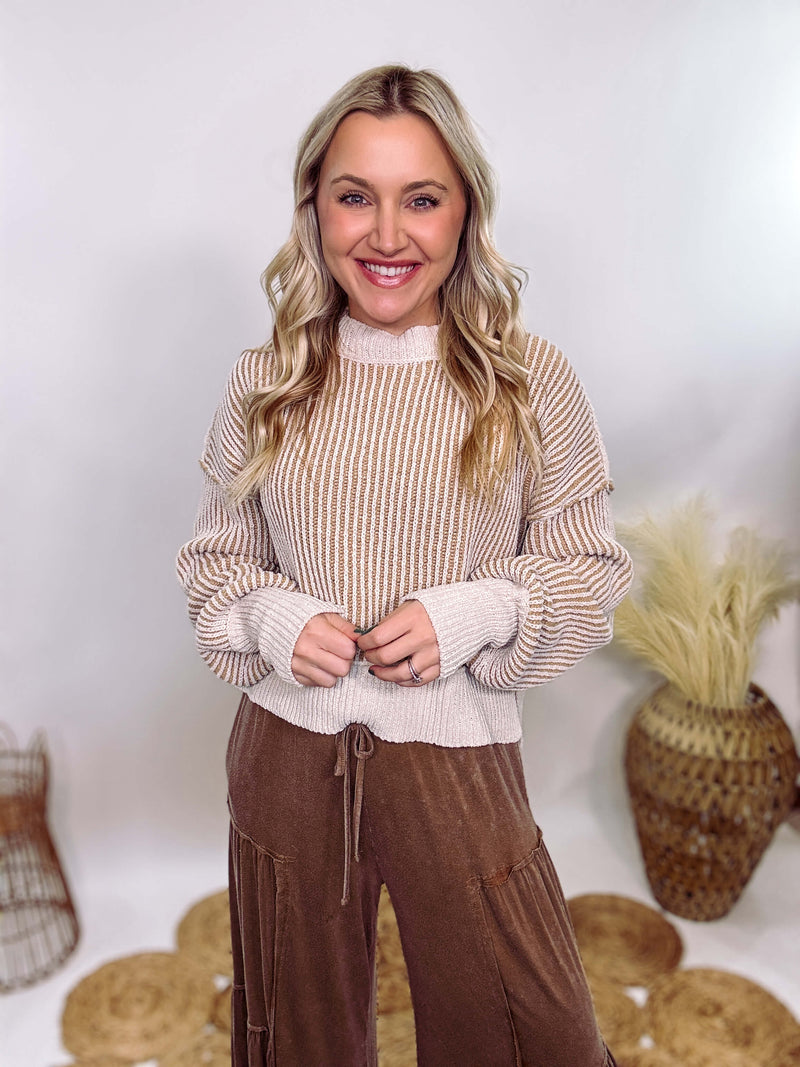 Very J Two-tone neutral ribbed sweater featuring a cream body with light brown ribbed detailing, round neck, and loose fit. Made from 100% polyester with a soft, non-scratchy feel. Styled with a neutral beanie and kick flare denim for a cozy winter look.