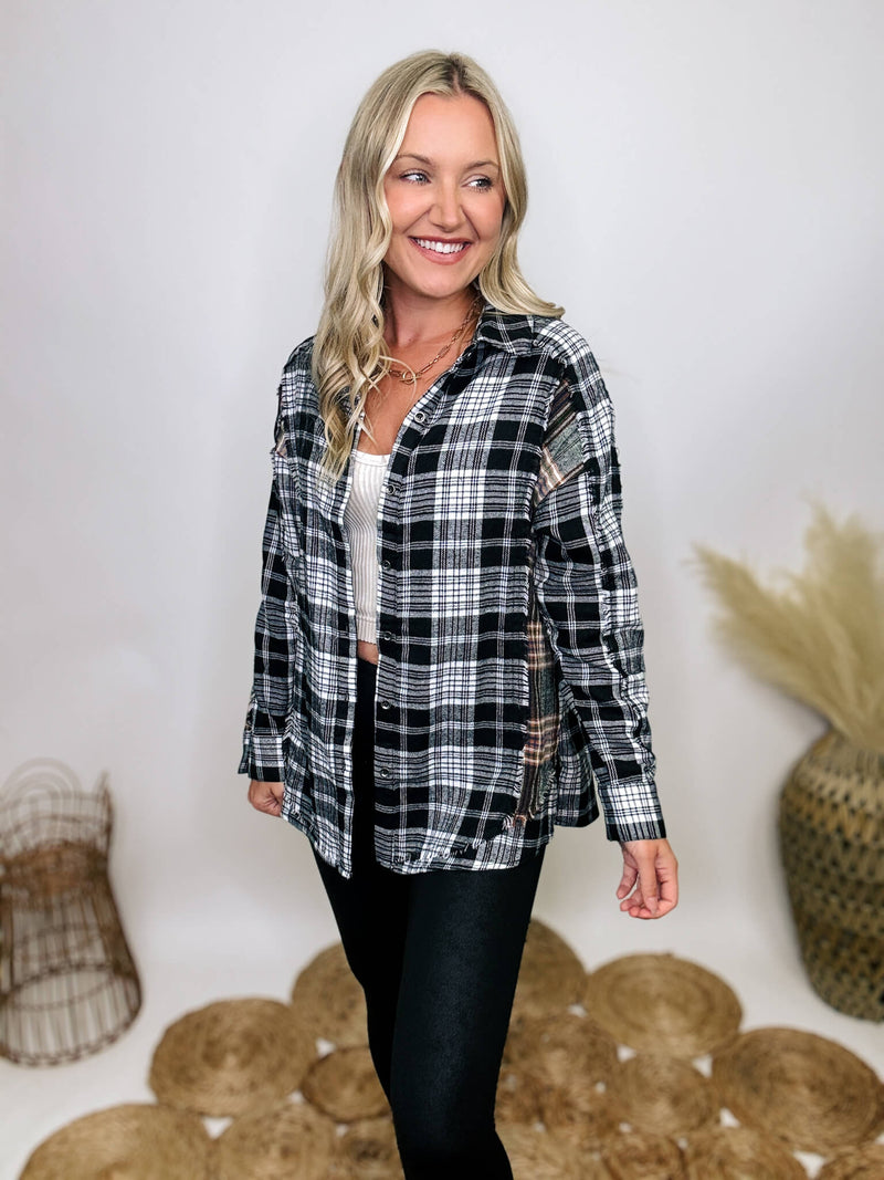 Black and white plaid flannel shirt with subtle olive, featuring frayed hem details, button-down front, and long sleeves, styled with a basic tank or graphic tee.