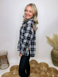 Black and white plaid flannel shirt with subtle olive, featuring frayed hem details, button-down front, and long sleeves, styled with a basic tank or graphic tee.
