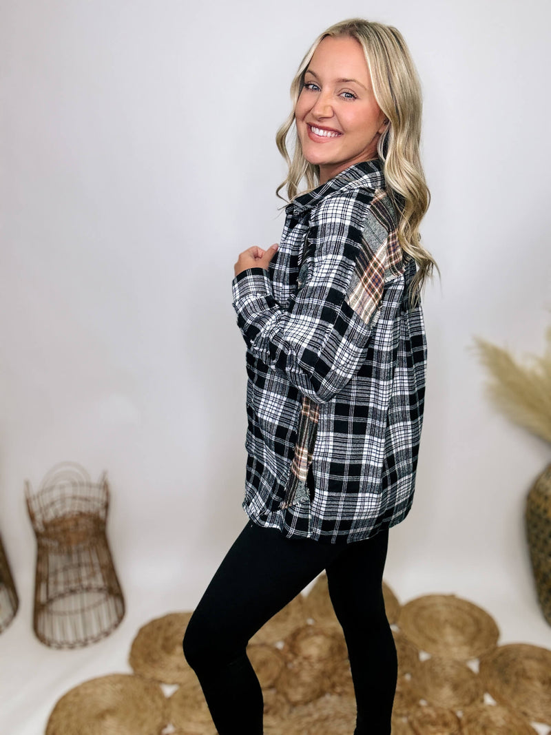 Black and white plaid flannel shirt with subtle olive, featuring frayed hem details, button-down front, and long sleeves, styled with a basic tank or graphic tee.