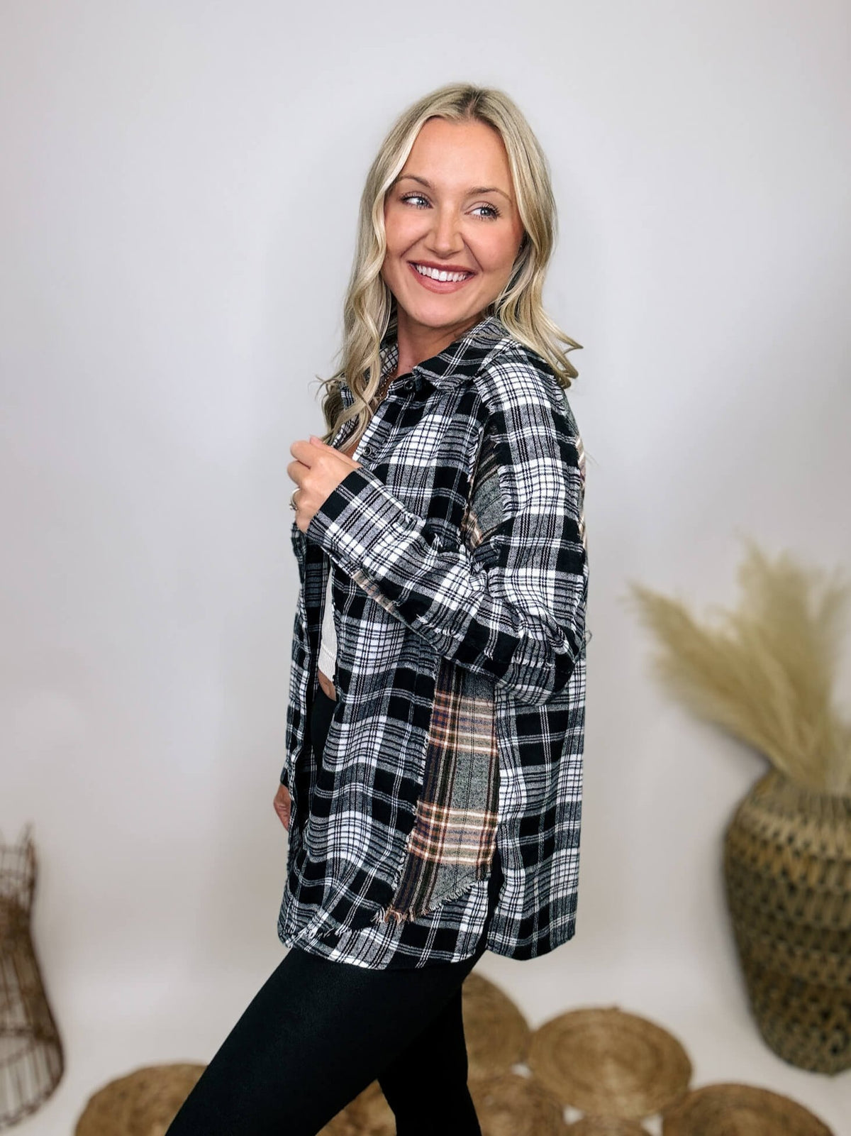 Black and white plaid flannel shirt with subtle olive, featuring frayed hem details, button-down front, and long sleeves, styled with a basic tank or graphic tee.