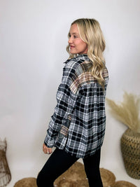 Black and white plaid flannel shirt with subtle olive, featuring frayed hem details, button-down front, and long sleeves, styled with a basic tank or graphic tee.