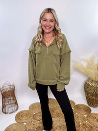 Olive mock neck quarter zip oversized sweatshirt with raw edge details, exposed seams, and cozy fleece fabric. Features a relaxed fit, patch pockets, and long sleeves with drop shoulders