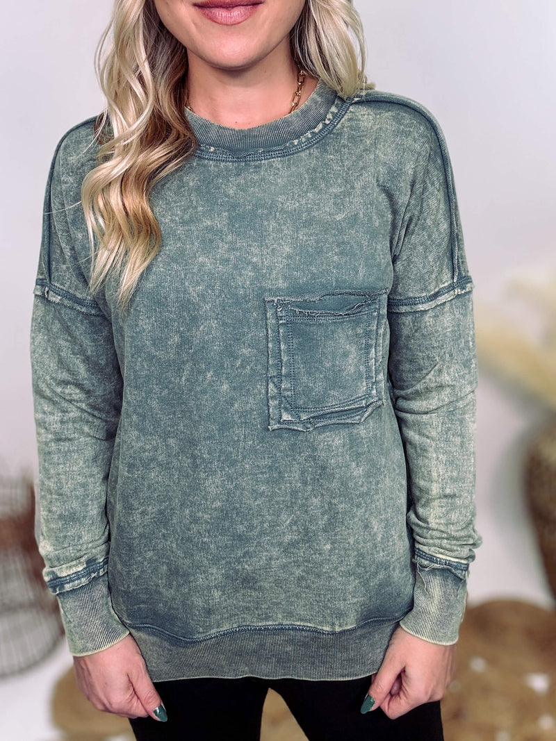 Zenana Ash Jade Green Acid Washed Raw Hem Pocket Pullover with raw edge seams, chest and side pockets, ribbed wrist and hem detailing, and a cozy relaxed fit.